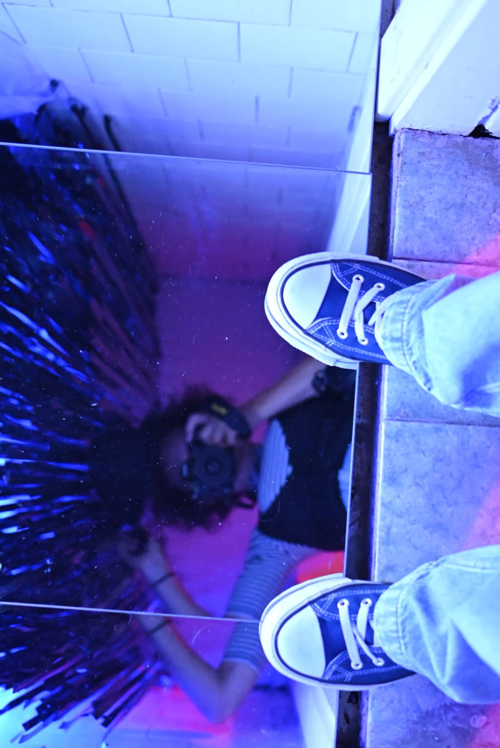 Mirror Room Photo of a room covered in mirrors, VHS tapes hanging from the ceiling