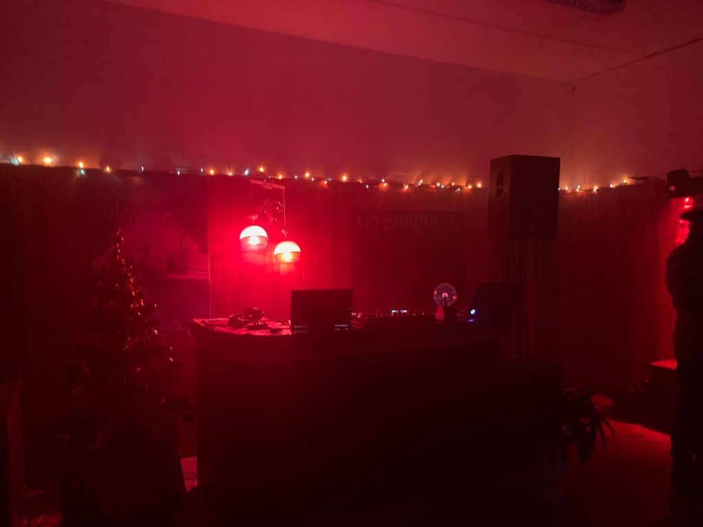 Ready to dance Empty dancefloor with red lighting and a christmas tree on the left
