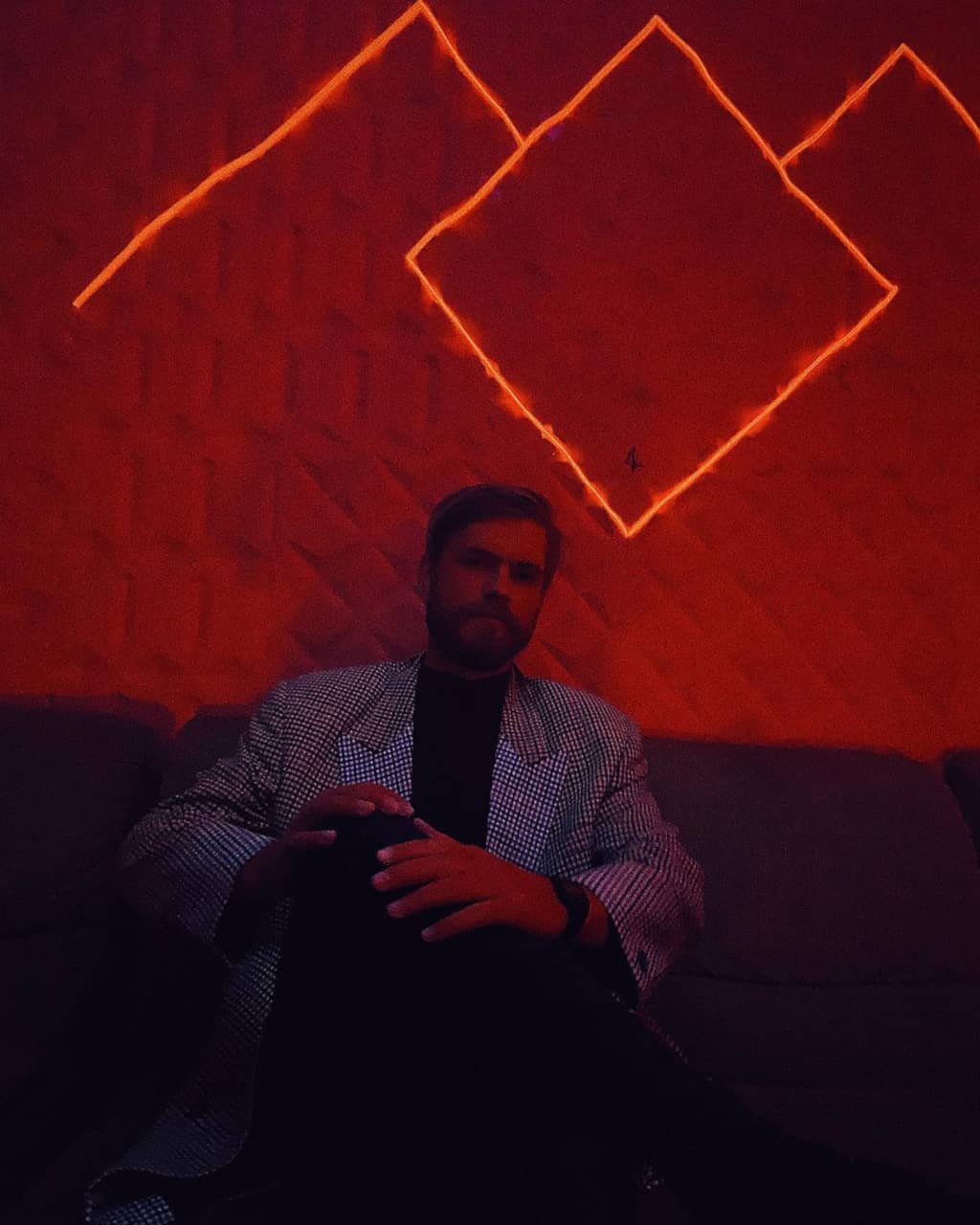 Business mode Person sitting on a cozy chair with Twin Peaks black lodge symbol behind them