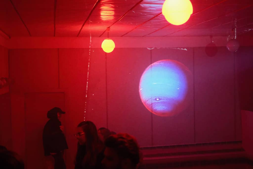 Pool Room with spooky VHS tapes Wall with a VHS movie being projected which is showing a planet