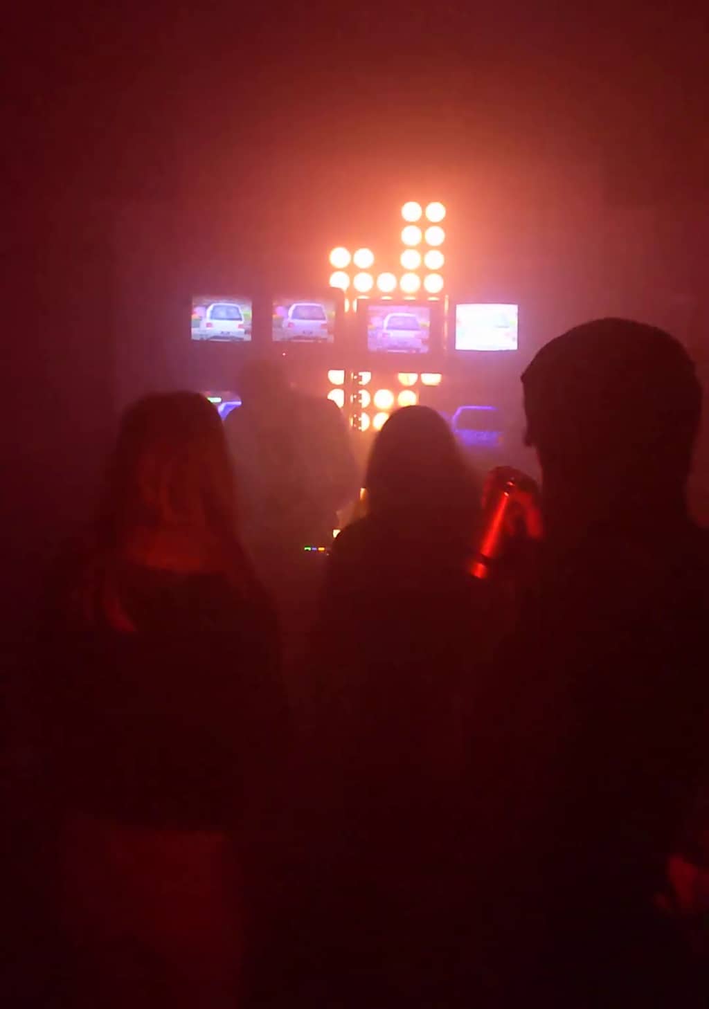 Dance floor Dance floor with a bunch of people dancing and a performer visible in the background with television screens