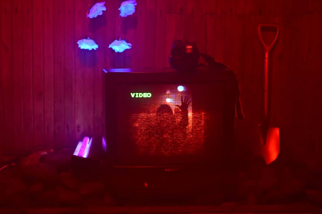 TV Sauna TV in a sauna, golden shovel on the right, camera on top recording visitors